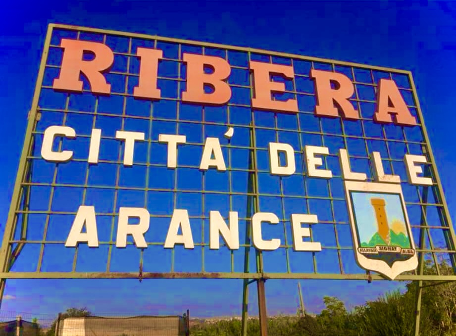Das Schild Ribera – Città delle Arance vor blauem Himmel.